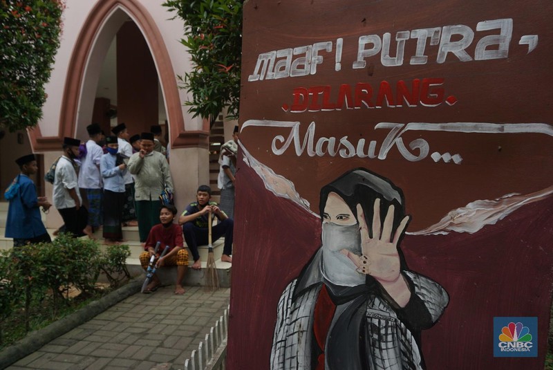 Suasana Pesantren An-Nuqthah, Tangerang Banten, sejumlah santri kembali berdatangan usai belajar di rumah selama pandemi corona. 18/6/20. CNBC Indonesia/Tri Susilo Para santri juga harus mengenakan masker walaupun sudah berada di dalam pesantren. Pemulangan santri ke pesantren dilakukan selama beberapa tahap dalam satu minggu. Ini dilakukan guna menghindari penumpukan orang dalam satu waktu. Pada tahap awal, santri yang kembali baru sekira 15 persen dari total 1.500 santri. Sementara, sebagian orangtua masih khawatir akan penularan virus corona di dalam pesantren. Karena itu mereka membekali buah hatinya dengan cairan pembersih tangan, vitamin dan persediaan masker. Sementara pengelola pesantren menyebut, kebijakan membuka kembali aktifitas belajar tatap muka karena pihaknya merasa sudah sanggup menerapkan protokol kesehatan di dalam pesantren. Guna penerapan protokol kesehatan, pihak pengelola melakukan sterilisasi lingkungan pesantren secara rutin, menata ulang kamar-kamar tidur para santri, dan menjaga jarak antar individu, baik dalam setiap kegiatan belajar mengajar maupun ibadah. Pantauan CNBC Indonesia Dilapangan para santri yang melakukan ibadah harus tetap jaga jarak didalam masjid. Santri yang balik ke pesantren belum semuanya berdatangan, kemungkinan gelombang kedua akan datang pada bulan Juli 2020 mendatang. (CNBC Indonesia/ Tri Susilo)