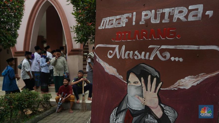 Suasana Pesantren An-Nuqthah, Tangerang Banten, sejumlah santri kembali berdatangan usai belajar di rumah selama pandemi corona. 18/6/20. CNBC Indonesia/Tri Susilo Para santri juga harus mengenakan masker walaupun sudah berada di dalam pesantren. Pemulangan santri ke pesantren dilakukan selama beberapa tahap dalam satu minggu. Ini dilakukan guna menghindari penumpukan orang dalam satu waktu. Pada tahap awal, santri yang kembali baru sekira 15 persen dari total 1.500 santri. Sementara, sebagian orangtua masih khawatir akan penularan virus corona di dalam pesantren. Karena itu mereka membekali buah hatinya dengan cairan pembersih tangan, vitamin dan persediaan masker. Sementara pengelola pesantren menyebut, kebijakan membuka kembali aktifitas belajar tatap muka karena pihaknya merasa sudah sanggup menerapkan protokol kesehatan di dalam pesantren. Guna penerapan protokol kesehatan, pihak pengelola melakukan sterilisasi lingkungan pesantren secara rutin, menata ulang kamar-kamar tidur para santri, dan menjaga jarak antar individu, baik dalam setiap kegiatan belajar mengajar maupun ibadah. Pantauan CNBC Indonesia Dilapangan para santri yang melakukan ibadah harus tetap jaga jarak didalam masjid. Santri yang balik ke pesantren belum semuanya berdatangan, kemungkinan gelombang kedua akan datang pada bulan Juli 2020 mendatang. (CNBC Indonesia/ Tri Susilo)