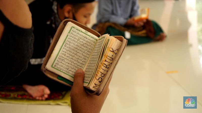 Suasana Pesantren An-Nuqthah, Tangerang Banten, sejumlah santri kembali berdatangan usai belajar di rumah selama pandemi corona. 18/6/20. CNBC Indonesia/Tri Susilo Para santri juga harus mengenakan masker walaupun sudah berada di dalam pesantren. Pemulangan santri ke pesantren dilakukan selama beberapa tahap dalam satu minggu. Ini dilakukan guna menghindari penumpukan orang dalam satu waktu. Pada tahap awal, santri yang kembali baru sekira 15 persen dari total 1.500 santri. Sementara, sebagian orangtua masih khawatir akan penularan virus corona di dalam pesantren. Karena itu mereka membekali buah hatinya dengan cairan pembersih tangan, vitamin dan persediaan masker. Sementara pengelola pesantren menyebut, kebijakan membuka kembali aktifitas belajar tatap muka karena pihaknya merasa sudah sanggup menerapkan protokol kesehatan di dalam pesantren. Guna penerapan protokol kesehatan, pihak pengelola melakukan sterilisasi lingkungan pesantren secara rutin, menata ulang kamar-kamar tidur para santri, dan menjaga jarak antar individu, baik dalam setiap kegiatan belajar mengajar maupun ibadah. Pantauan CNBC Indonesia Dilapangan para santri yang melakukan ibadah harus tetap jaga jarak didalam masjid. Santri yang balik ke pesantren belum semuanya berdatangan, kemungkinan gelombang kedua akan datang pada bulan Juli 2020 mendatang. (CNBC Indonesia/ Tri Susilo)