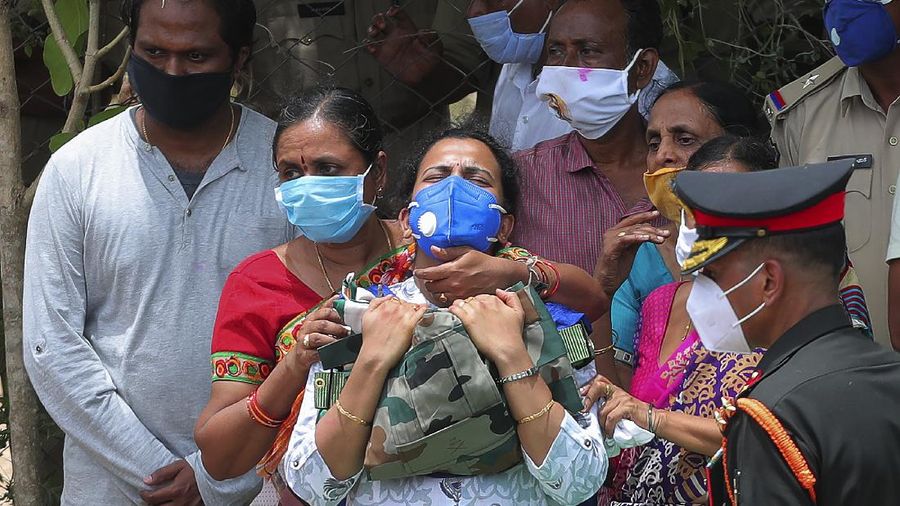 Santoshi wife of Indian Army Colonel B. Santosh Babu, mourns after receiving the uniform and National flag during the last rites ceremony at their home town at Suryapet, about 140 kilometers (87.5 miles) from Hyderabad, India, Thursday, June 18, 2020. Babu was among the twenty Indian troops who were killed in the clash Monday night that was the deadliest conflict between the sides in 45 years. India on Thursday cautioned China against making