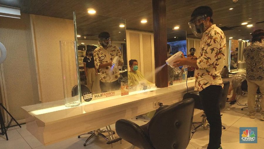 Karyawan melayani pelanggan yang melakukan perawatan rambut di Alfons Salon, Jakarta, Senin (19/6/2020). CNBC Indonesia/Tri Susilo 

Pemprov DKI Jakarta melakukan penerapan Pembatasan Sosial Berskala Besar (PSBB) transisi membuka kembali operasional unit usaha salon dan tata rambut dengan menerapkan protokol kesehatan sesuai anjuran seperti pengukuran suhu tubuh, penggunaan masker bagi karyawan dan konsumen salon, sterilisasi peralatan, pemakaian pelindung wajah bagi karyawan, dan sistem reservasi bagi konsumen.   

Rina Rengganis selaku General Meneger mengatakan karena anjuran protokol pemerintah tentang Covid-19, jumlah karyawan yang bekerja di Alfons & Haircode Salon juga melakukan swab tes sebelum masuk dan jumlahnya kita batasi menjadi sekitar 50 persen karyawan. Dan mereka akan menyetujui protokol untuk menaati protokol ini,