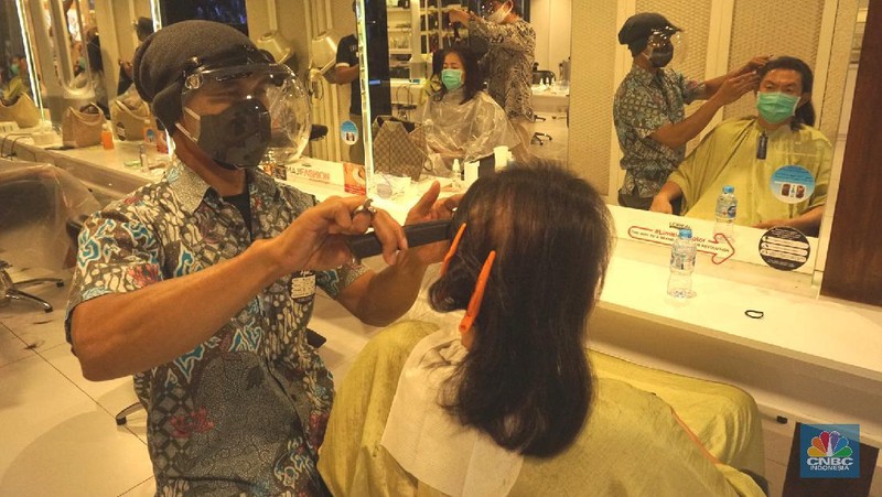 Karyawan melayani pelanggan yang melakukan perawatan rambut di Alfons Salon, Jakarta, Senin (19/6/2020). CNBC Indonesia/Tri Susilo 

Pemprov DKI Jakarta melakukan penerapan Pembatasan Sosial Berskala Besar (PSBB) transisi membuka kembali operasional unit usaha salon dan tata rambut dengan menerapkan protokol kesehatan sesuai anjuran seperti pengukuran suhu tubuh, penggunaan masker bagi karyawan dan konsumen salon, sterilisasi peralatan, pemakaian pelindung wajah bagi karyawan, dan sistem reservasi bagi konsumen.   

Rina Rengganis selaku General Meneger mengatakan karena anjuran protokol pemerintah tentang Covid-19, jumlah karyawan yang bekerja di Alfons & Haircode Salon juga melakukan swab tes sebelum masuk dan jumlahnya kita batasi menjadi sekitar 50 persen karyawan. Dan mereka akan menyetujui protokol untuk menaati protokol ini,