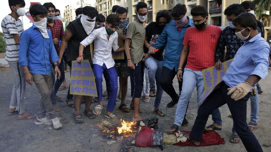 Indians trample on a burning effigy of Chinese President Xi Jinping during a protest against China in Ahmedabad, India, Thursday, June 18, 2020. Twenty Indian troops were killed in a clash with Chinese soldiers in the Galwan Valley area Monday night that was the deadliest conflict between the sides in 45 years. (AP Photo/Ajit Solanki)