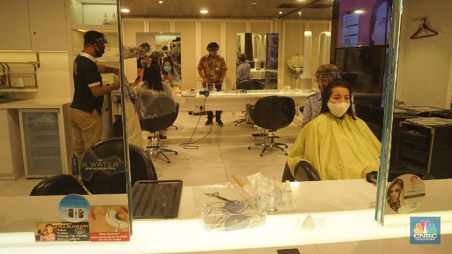 Karyawan melayani pelanggan yang melakukan perawatan rambut di Alfons Salon, Jakarta, Senin (19/6/2020). CNBC Indonesia/Tri Susilo
Pemprov DKI Jakarta melakukan penerapan Pembatasan Sosial Berskala Besar (PSBB) transisi membuka kembali operasional unit usaha salon dan tata rambut dengan menerapkan protokol kesehatan sesuai anjuran seperti pengukuran suhu tubuh, penggunaan masker bagi karyawan dan konsumen salon, sterilisasi peralatan, pemakaian pelindung wajah bagi karyawan, dan sistem reservasi bagi konsumen.
Rina Rengganis selaku General Meneger mengatakan karena anjuran protokol pemerintah tentang Covid-19, jumlah karyawan yang bekerja di Alfons & Haircode Salon juga melakukan swab tes sebelum masuk dan jumlahnya kita batasi menjadi sekitar 50 persen karyawan. Dan mereka akan menyetujui protokol untuk menaati protokol ini,