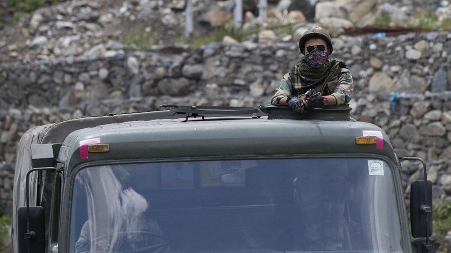 An Indian army soldier guards atop one of the vehicles as an army convoy moves on the Srinagar- Ladakh highway at Gagangeer, north-east of Srinagar, India, Wednesday, June 17, 2020. Indian security forces said neither side fired any shots in the clash in the Ladakh region late Monday that was the first deadly confrontation on the disputed border between India and China since 1975. China said Wednesday that it is seeking a peaceful resolution to its Himalayan border dispute with India following the death of 20 Indian soldiers in the most violent confrontation in decades. (AP Photo/Mukhtar Khan)