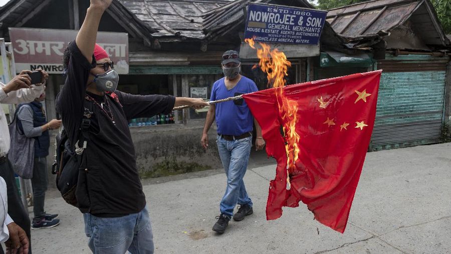 Tenzin Tsundue, an exile Tibetan activist burns a Chinese national flag during a one-man protest in Dharmsala, India, Thursday, June 18, 2020. Tsundue, said he was burning the flag as a symbolic protest against Chinese invasion of Indian territory and its continued occupation of Tibet. Twenty Indian troops were killed in a clash with Chinese soldiers in the Galwan Valley area Monday night that was the deadliest conflict between the sides in 45 years. (AP Photo/Ashwini Bhatia)