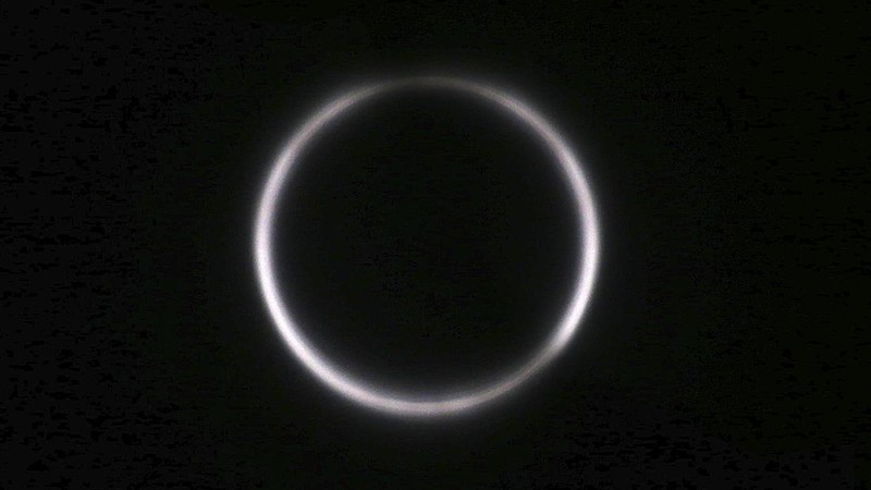 A man tries to take photos as a solar eclipse is seen over the sky in Chiayi City, southwest of Taiwan, Sunday, June 21, 2020. (AP Photo/Chiang Ying-ying)