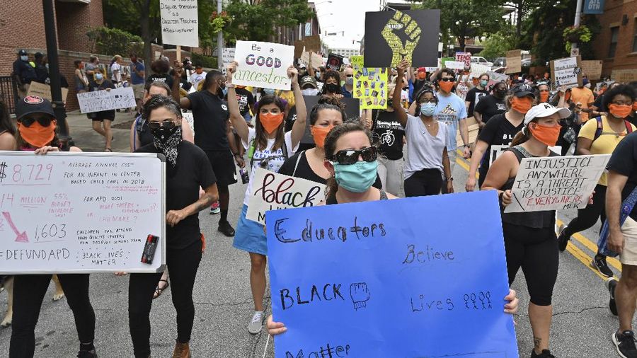 Educators march past Atlanta Public Schools Headquarters after they made a short stop on Friday, June 26, 2020, in Atlanta. The Educators for Black Lives March started at 3 p.m. at Rosa L. Burney Park on Windsor Street south of downtown. Organizers planned brief stops outside the city jail, the headquarters for Atlanta Public Schools, the Georgia Department of Education, and Atlanta City Hall, before arriving at their destination: Liberty Plaza across the street from the Georgia State Capitol. (Hyosub Shin/Atlanta Journal-Constitution via AP)