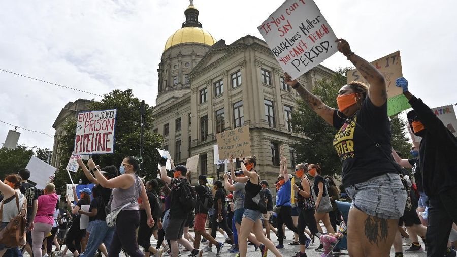 Educators march past the Georgia State Capitol while the last day of the legislative session is in session at Georgia State Capitol, Friday, June 26, 2020, in Atlanta. The Educators for Black Lives March started at 3 p.m. at Rosa L. Burney Park on Windsor Street south of downtown. Organizers planned brief stops outside the city jail, the headquarters for Atlanta Public Schools, the Georgia Department of Education, and Atlanta City Hall, before arriving at their destination: Liberty Plaza across the street from the Georgia State Capitol. (Hyosub Shin/Atlanta Journal-Constitution via AP)