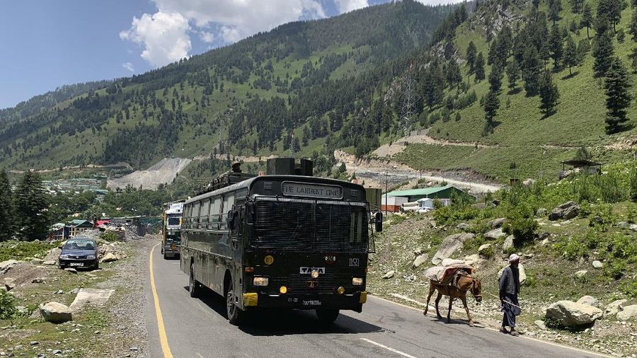 A Kashmiri Bakarwal nomad walks as an Indian army convoy moves on the Srinagar- Ladakh highway at Gagangeer, north-east of Srinagar, Indian controlled Kashmir, Thursday, June 18, 2020. India on Thursday cautioned China against making 
