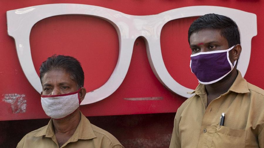 Security officers hold flowers given to them as a gesture of gratitude at the end of a free medical camp in Dharavi, one of Asia's biggest slums, in Mumbai, India, Friday, June 26, 2020. India is the fourth hardest-hit country by the pandemic in the world after the U.S., Russia and Brazil. (AP Photo/Rafiq Maqbool)