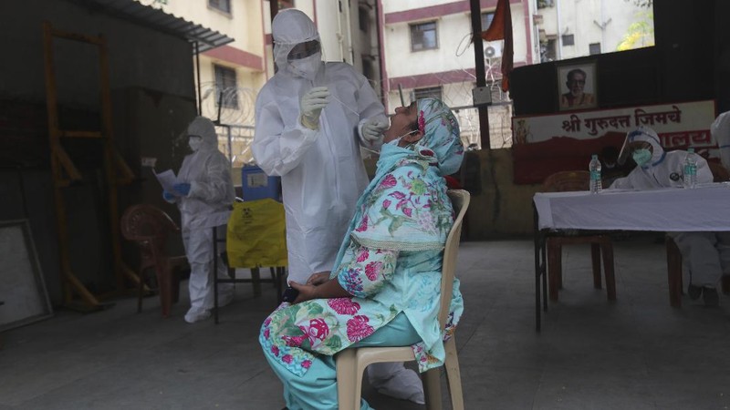 Security officers hold flowers given to them as a gesture of gratitude at the end of a free medical camp in Dharavi, one of Asia's biggest slums, in Mumbai, India, Friday, June 26, 2020. India is the fourth hardest-hit country by the pandemic in the world after the U.S., Russia and Brazil. (AP Photo/Rafiq Maqbool)