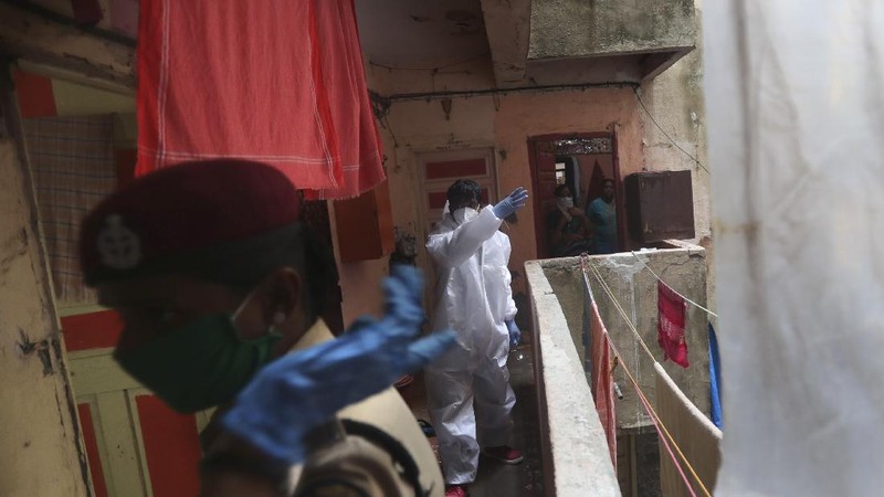 Security officers hold flowers given to them as a gesture of gratitude at the end of a free medical camp in Dharavi, one of Asia's biggest slums, in Mumbai, India, Friday, June 26, 2020. India is the fourth hardest-hit country by the pandemic in the world after the U.S., Russia and Brazil. (AP Photo/Rafiq Maqbool)