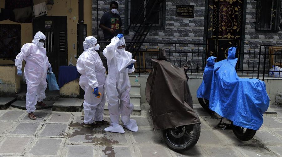Security officers hold flowers given to them as a gesture of gratitude at the end of a free medical camp in Dharavi, one of Asia's biggest slums, in Mumbai, India, Friday, June 26, 2020. India is the fourth hardest-hit country by the pandemic in the world after the U.S., Russia and Brazil. (AP Photo/Rafiq Maqbool)