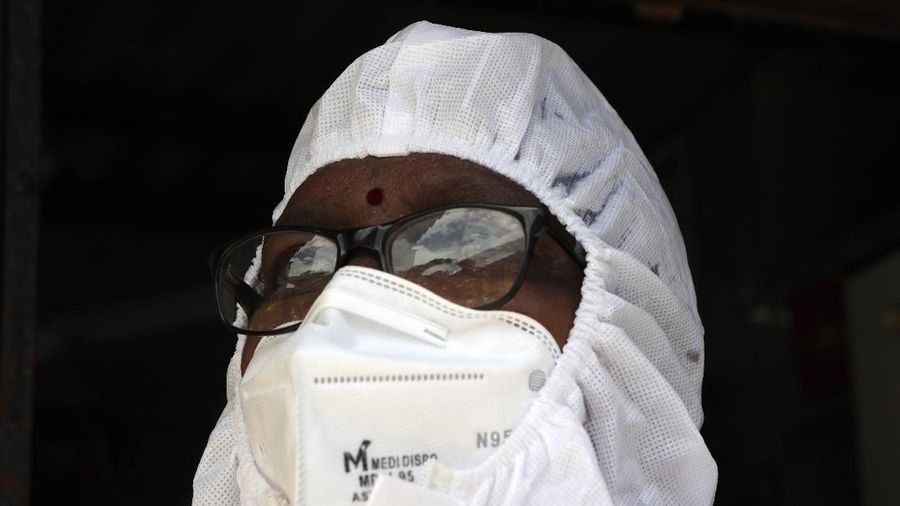 A health worker takes a moment after screening people  for COVID-19 at Dharavi slum in Mumbai, India, Wednesday, June 24, 2020. India is the fourth hardest-hit country by the pandemic in the world after the U.S., Russia and Brazil. (AP Photo/Rajanish Kakade)