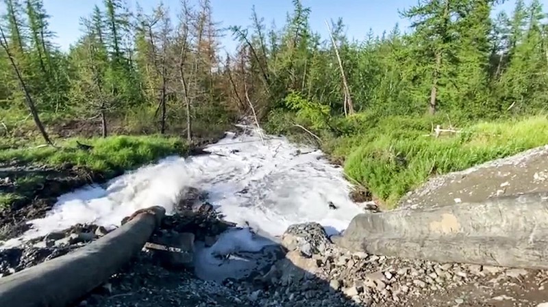 In this handout frame taken from video released Sunday June 28, 2020, by Novaya Gazeta, showing what the report is water from a Norilsk Nickel enrichment plant gushing out of a pipe and into a river which also runs into the lake near Norilsk, 2,900 kilometers (1,800 miles) northeast of Moscow, Russia. Russia's main criminal investigation body has launched a probe after a report that a nickel-processing plant was pumping water contaminated with heavy metals into the Arctic tundra.  (Elena Kostyuchenko, Novaya Gazeta via AP)