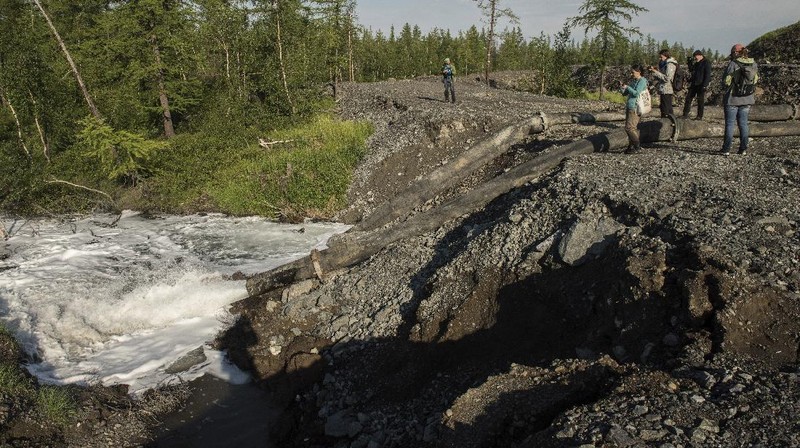 In this handout frame taken from video released Sunday June 28, 2020, by Novaya Gazeta, showing what the report is water from a Norilsk Nickel enrichment plant gushing out of a pipe and into a river which also runs into the lake near Norilsk, 2,900 kilometers (1,800 miles) northeast of Moscow, Russia. Russia's main criminal investigation body has launched a probe after a report that a nickel-processing plant was pumping water contaminated with heavy metals into the Arctic tundra.  (Elena Kostyuchenko, Novaya Gazeta via AP)