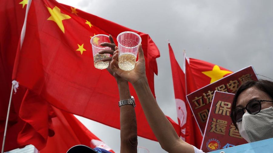 Pro-China supporters holding Chinese national flags, toast during a rally to celebrate the approval of a national security law for Hong Kong, in Hong Kong, Tuesday, June 30, 2020. Hong Kong media are reporting that China has approved a contentious law that would allow authorities to crack down on subversive and secessionist activity in Hong Kong, sparking fears that it would be used to curb opposition voices in the semi-autonomous territory. (AP Photo/Kin Cheung)