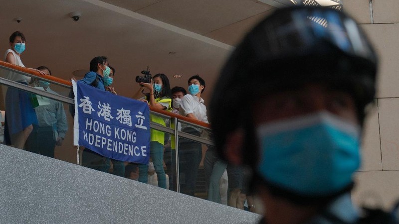 Protesters gather at a shopping mall in Central during a pro-democracy protest against Beijing's national security law in Hong Kong, Tuesday, June 30, 2020. Hong Kong media are reporting that China has approved a contentious law that would allow authorities to crack down on subversive and secessionist activity in Hong Kong, sparking fears that it would be used to curb opposition voices in the semi-autonomous territory. The placard, second from left, reads: 