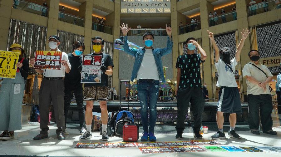 Protesters gather at a shopping mall in Central during a pro-democracy protest against Beijing's national security law in Hong Kong, Tuesday, June 30, 2020. Hong Kong media are reporting that China has approved a contentious law that would allow authorities to crack down on subversive and secessionist activity in Hong Kong, sparking fears that it would be used to curb opposition voices in the semi-autonomous territory. The placard, second from left, reads: