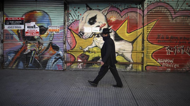 A man runs in a park during a government-ordered lockdown to curb the spread of the new coronavirus in Buenos Aires, Argentina, Thursday, June 25, 2020. (AP Photo/Natacha Pisarenko)