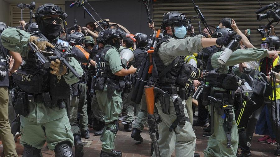 A reporter is helped by police and others after being with sprayed pepper spray in Causeway Bay before the annual handover march in Hong Kong, Wednesday, July. 1, 2020. Hong Kong marked the 23rd anniversary of its handover to China in 1997, and just one day after China enacted a national security law that cracks down on protests in the territory. (AP Photo/Vincent Yu)