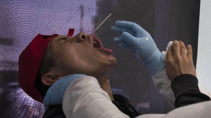 Health worker Ulises Cadena Santana uses a nasal swab to test a man for the new coronavirus, at the Central de Abasto market in Mexico City, Thursday, June 18, 2020. Cadena Santana works taking as many as 100 COVID-19 test samples per day at a series of emergency testing and triage tents set up outside the market. (AP Photo/Marco Ugarte)