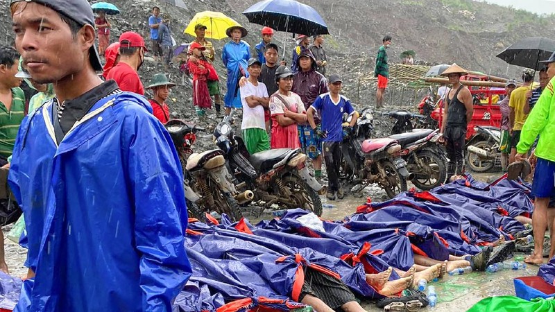 In this photo released from Myanmar Fire Service Department, rescuers carry a recovered body of a victim in a landslide from a jade mining area in Hpakant, Kachin state, northern Myanmar Thursday, July 2, 2020. Myanmar government says a landslide at a jade mine has killed dozens of people. (Myanmar Fire Service Department via AP)