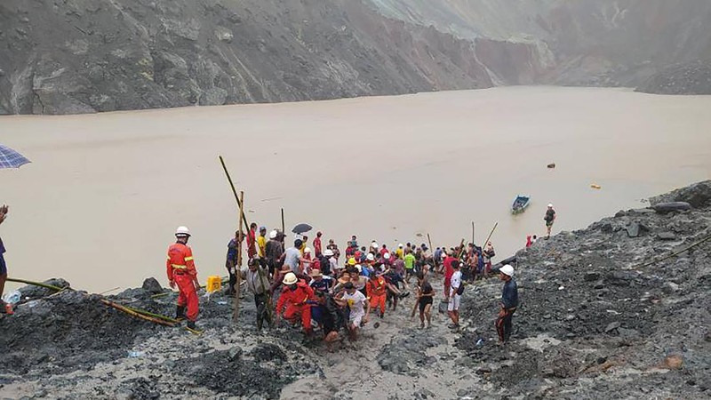 In this photo released from Myanmar Fire Service Department, rescuers carry a recovered body of a victim in a landslide from a jade mining area in Hpakant, Kachin state, northern Myanmar Thursday, July 2, 2020. Myanmar government says a landslide at a jade mine has killed dozens of people. (Myanmar Fire Service Department via AP)