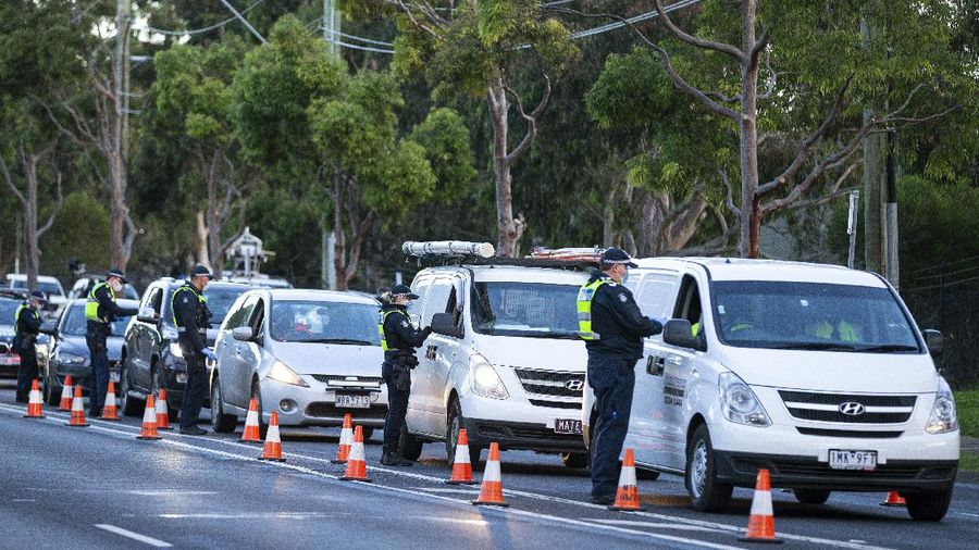 Police check drivers at a roadblock in suburban Melbourne, Australia, Thursday, July 2, 2020. Thousands of residents in dozens of suburbs of Melbourne, are preparing to lockdown for a month with the Victoria state premier warning a state-wide shutdown is possible if coronavirus cases continue to rise. (Daniel Pockett/AAP Image via AP)