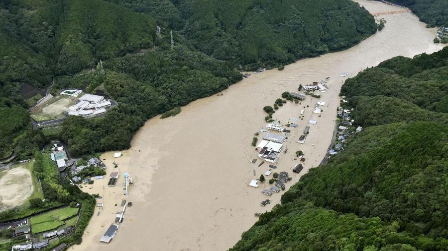 A bridge over the Kuma River is washed away by a flood in Yatsushiro, Kumamoto prefecture, southwestern Japan, Saturday, July 4, 2020. Heavy rain triggered flooding and mudslides on Saturday, leaving more than a dozen missing and others stranded on rooftops waiting to be rescued. More than 75,000 residents in the prefectures of Kumamoto and Kagoshima were asked to evacuate following pounding rains overnight. (Kyodo News via AP)