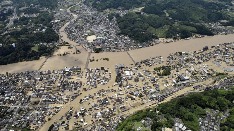 A bridge over the Kuma River is washed away by a flood in Yatsushiro, Kumamoto prefecture, southwestern Japan, Saturday, July 4, 2020. Heavy rain triggered flooding and mudslides on Saturday, leaving more than a dozen missing and others stranded on rooftops waiting to be rescued. More than 75,000 residents in the prefectures of Kumamoto and Kagoshima were asked to evacuate following pounding rains overnight. (Kyodo News via AP)