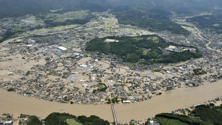 A bridge over the Kuma River is washed away by a flood in Yatsushiro, Kumamoto prefecture, southwestern Japan, Saturday, July 4, 2020. Heavy rain triggered flooding and mudslides on Saturday, leaving more than a dozen missing and others stranded on rooftops waiting to be rescued. More than 75,000 residents in the prefectures of Kumamoto and Kagoshima were asked to evacuate following pounding rains overnight. (Kyodo News via AP)