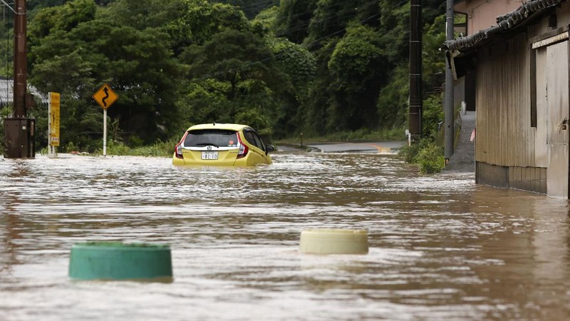 A bridge over the Kuma River is washed away by a flood in Yatsushiro, Kumamoto prefecture, southwestern Japan, Saturday, July 4, 2020. Heavy rain triggered flooding and mudslides on Saturday, leaving more than a dozen missing and others stranded on rooftops waiting to be rescued. More than 75,000 residents in the prefectures of Kumamoto and Kagoshima were asked to evacuate following pounding rains overnight. (Kyodo News via AP)