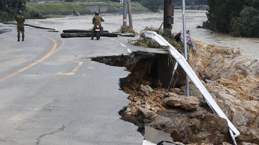 A road is damaged following a heavy rain in Kumamura, Kumamoto prefecture, southern Japan Saturday, July 4, 2020. Heavy rain in southern Japan triggered flooding and mudslides on Saturday, leaving more than a dozen people presumed dead, some missing and dozens stranded on rooftops waiting to be rescued, officials said. (Kyodo News via AP)