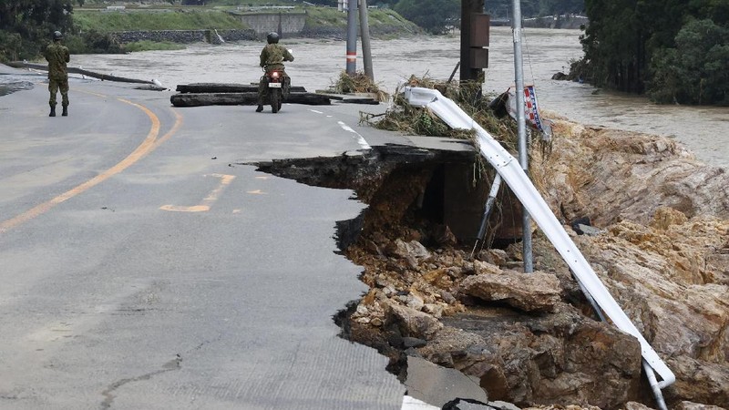 A road is damaged following a heavy rain in Kumamura, Kumamoto prefecture, southern Japan Saturday, July 4, 2020. Heavy rain in southern Japan triggered flooding and mudslides on Saturday, leaving more than a dozen people presumed dead, some missing and dozens stranded on rooftops waiting to be rescued, officials said. (Kyodo News via AP)