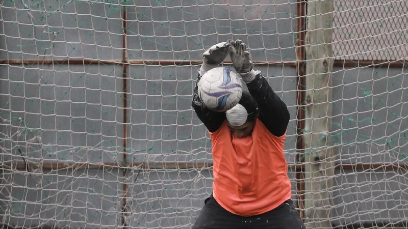 Martin Rodriguez controls the ball during an amateur soccer match at the Play Futbol 5 local club in Pergamino, Argentina, Wednesday, July 1, 2020. In order to continue playing amid government restrictions to curb the spread of the new coronavirus, the club divided its soccer field into 12 rectangles to mark limited areas for each player, keeping them from making physical contact. (AP Photo/Natacha Pisarenko)