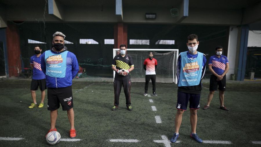 Martin Rodriguez controls the ball during an amateur soccer match at the Play Futbol 5 local club in Pergamino, Argentina, Wednesday, July 1, 2020. In order to continue playing amid government restrictions to curb the spread of the new coronavirus, the club divided its soccer field into 12 rectangles to mark limited areas for each player, keeping them from making physical contact. (AP Photo/Natacha Pisarenko)