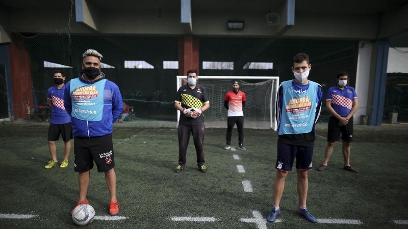Martin Rodriguez controls the ball during an amateur soccer match at the Play Futbol 5 local club in Pergamino, Argentina, Wednesday, July 1, 2020. In order to continue playing amid government restrictions to curb the spread of the new coronavirus, the club divided its soccer field into 12 rectangles to mark limited areas for each player, keeping them from making physical contact. (AP Photo/Natacha Pisarenko)