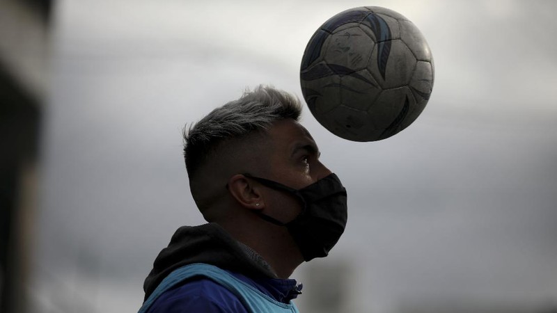 Martin Rodriguez controls the ball during an amateur soccer match at the Play Futbol 5 local club in Pergamino, Argentina, Wednesday, July 1, 2020. In order to continue playing amid government restrictions to curb the spread of the new coronavirus, the club divided its soccer field into 12 rectangles to mark limited areas for each player, keeping them from making physical contact. (AP Photo/Natacha Pisarenko)
