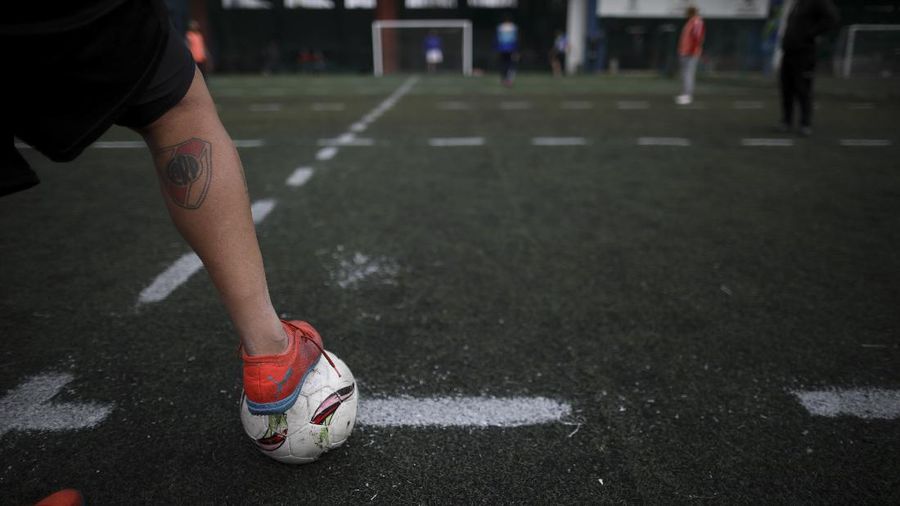 Martin Rodriguez controls the ball during an amateur soccer match at the Play Futbol 5 local club in Pergamino, Argentina, Wednesday, July 1, 2020. In order to continue playing amid government restrictions to curb the spread of the new coronavirus, the club divided its soccer field into 12 rectangles to mark limited areas for each player, keeping them from making physical contact. (AP Photo/Natacha Pisarenko)