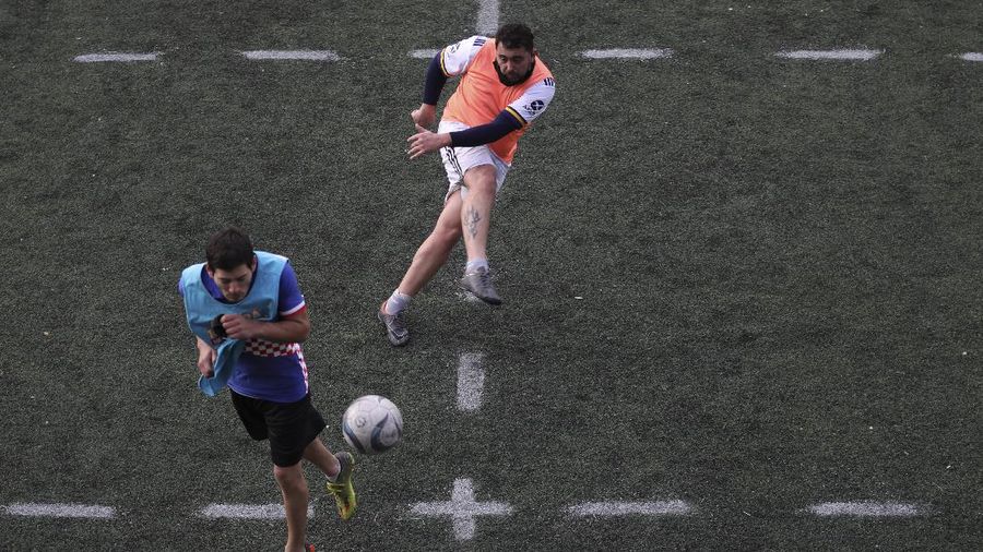Martin Rodriguez controls the ball during an amateur soccer match at the Play Futbol 5 local club in Pergamino, Argentina, Wednesday, July 1, 2020. In order to continue playing amid government restrictions to curb the spread of the new coronavirus, the club divided its soccer field into 12 rectangles to mark limited areas for each player, keeping them from making physical contact. (AP Photo/Natacha Pisarenko)