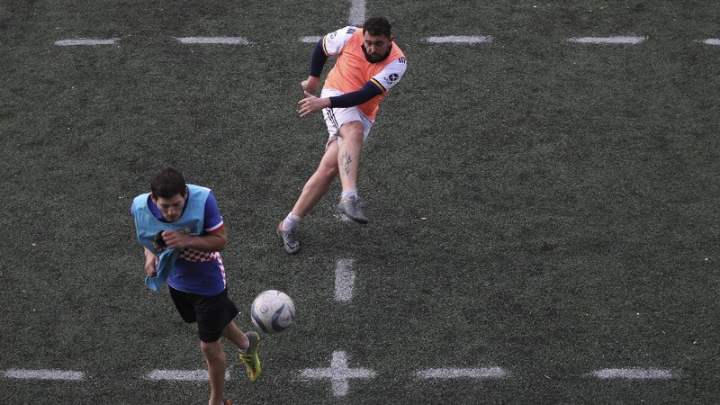 Martin Rodriguez controls the ball during an amateur soccer match at the Play Futbol 5 local club in Pergamino, Argentina, Wednesday, July 1, 2020. In order to continue playing amid government restrictions to curb the spread of the new coronavirus, the club divided its soccer field into 12 rectangles to mark limited areas for each player, keeping them from making physical contact. (AP Photo/Natacha Pisarenko)