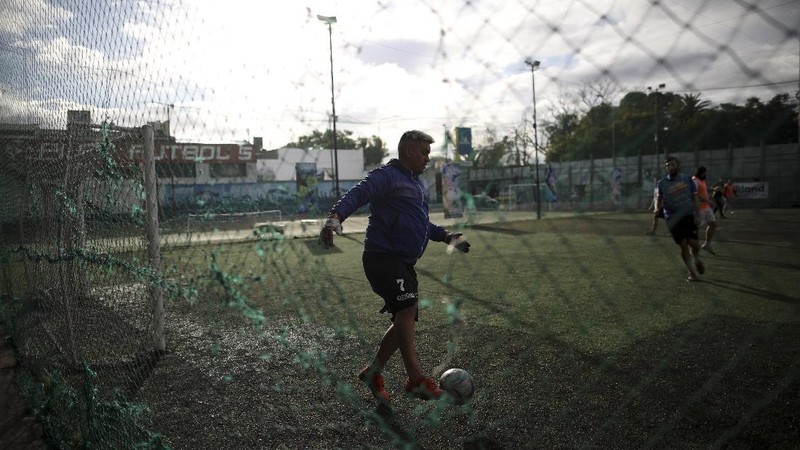 Martin Rodriguez controls the ball during an amateur soccer match at the Play Futbol 5 local club in Pergamino, Argentina, Wednesday, July 1, 2020. In order to continue playing amid government restrictions to curb the spread of the new coronavirus, the club divided its soccer field into 12 rectangles to mark limited areas for each player, keeping them from making physical contact. (AP Photo/Natacha Pisarenko)