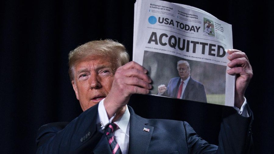 FILE - In this Feb. 6, 2020, file photo, President Donald Trump holds up a newspaper with the headline that reads 