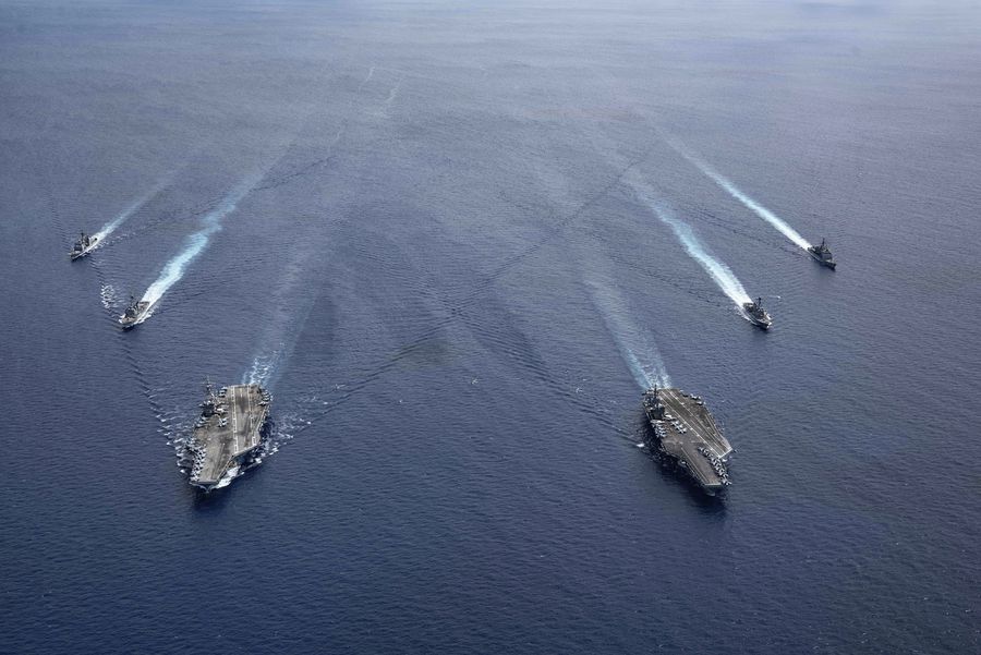 In this photo provided by U.S. Navy, the USS Ronald Reagan (CVN 76) and USS Nimitz (CVN 68) Carrier Strike Groups steam in formation, in the South China Sea, Monday, July 6, 2020. China on Monday, July 6, accused the U.S. of flexing its military muscles in the South China Sea by conducting joint exercises with two U.S. aircraft carrier groups in the strategic waterway.(Mass Communication Specialist 3rd Class Jason Tarleton/U.S. Navy via AP)