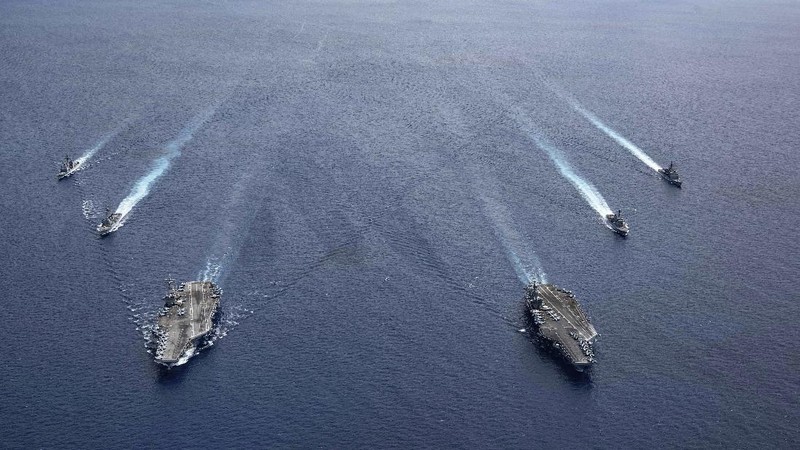 In this photo provided by U.S. Navy,  an F/A-18E Super Hornet lands on the flight deck of the USS Ronald Reagan (CVN 76), as USS Nimitz (CVN 68) steams alongside in the South China Sea, Monday, July 6, 2020. China on Monday, July 6, accused the U.S. of flexing its military muscles in the South China Sea by conducting joint exercises with two U.S. aircraft carrier groups in the strategic waterway.(Mass Communication Specialist 2nd Class Samantha Jetzer/U.S. Navy via AP)