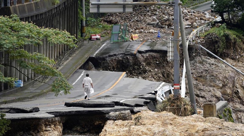 People carry a refrigerator out of a flooded office in Hitoyoshi city, Kumamoto prefecture, southwestern Japan, Tuesday, July 7, 2020. Floodwaters flowed down streets in southwestern Japanese towns hit by deadly rains that were expanding across the region Tuesday. (Yuki Sato/Kyodo News via AP)