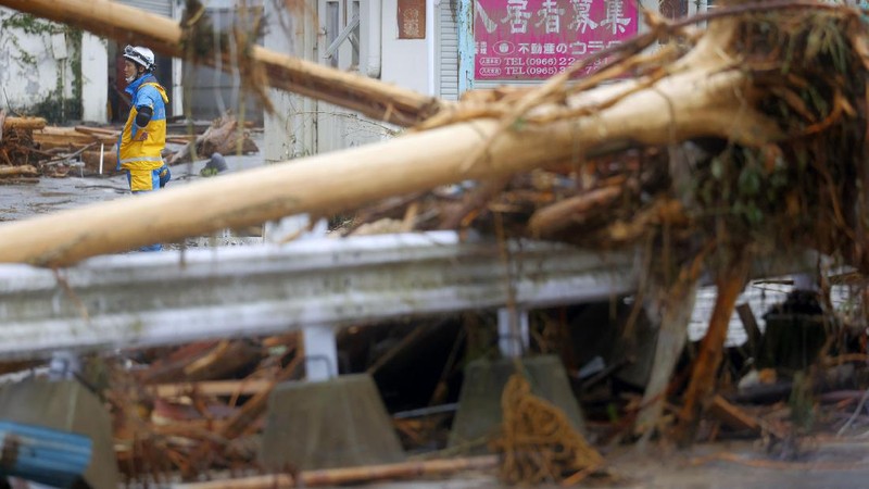 People carry a refrigerator out of a flooded office in Hitoyoshi city, Kumamoto prefecture, southwestern Japan, Tuesday, July 7, 2020. Floodwaters flowed down streets in southwestern Japanese towns hit by deadly rains that were expanding across the region Tuesday. (Yuki Sato/Kyodo News via AP)