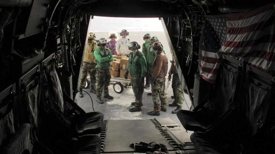 In this Friday, May 17, 2019, photo released by the U.S. Navy, Aviation Boatswain's Mate 2nd Class Nicholas Hawkins, from Houston, Texas, signals an MV-22 Osprey to land on the flight deck of the Nimitz-class aircraft carrier USS Abraham Lincoln in the Arabian Sea. Commercial airliners flying over the Persian Gulf risk being targeted by 